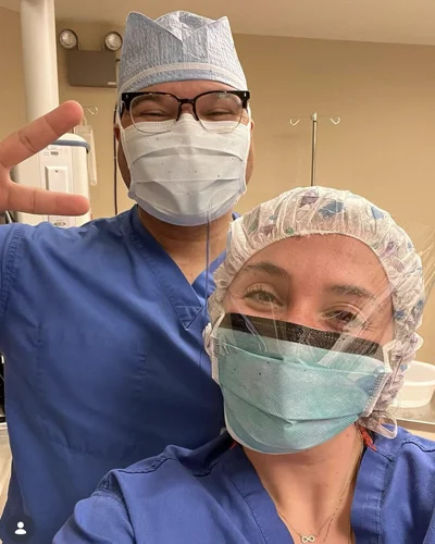 Abdul Walters and a fellow colleague pose in surgical scrubs and masks 