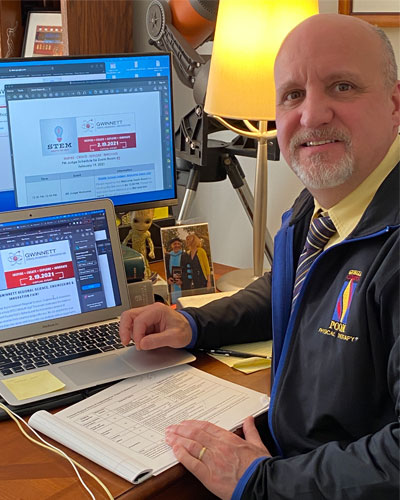 PCOM DPT faculty member Dr. Fabrizio judges students' projects from his desk during the 2021 Gwinnett virtual science fair.