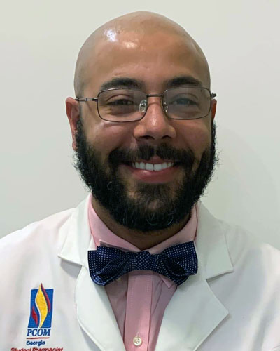 Headshot photo of pharmacy student Barry Brown, Jr. (PharmD '23) smiling and wearing a white coat.