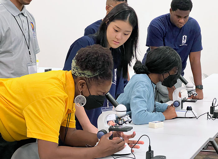 Gwinnett high schoolers work on an activity alongside PCOM Georgia med students at a summer STEM camp.