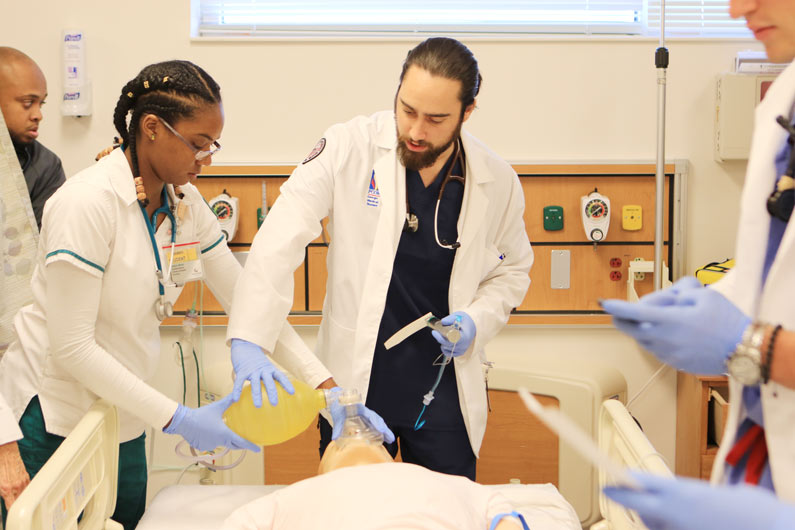 Danny Martinez and fellow students work with simulated patient