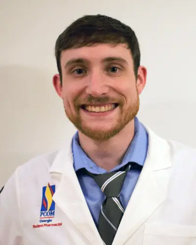 Headshot photograph of PCOM Georgia pharmacy student Andrew Wilson (PharmD '24) in his student physician white coat