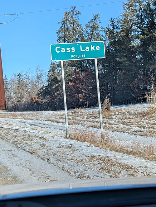 Road sign for Cass Lake, Minnesota on a snowy rural road side
