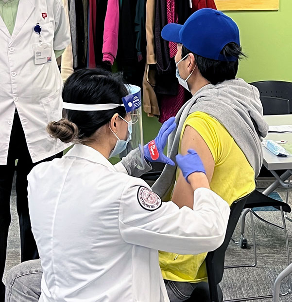 PCOM Georgia medical student administers a flu shot to a Gwinnett County resident