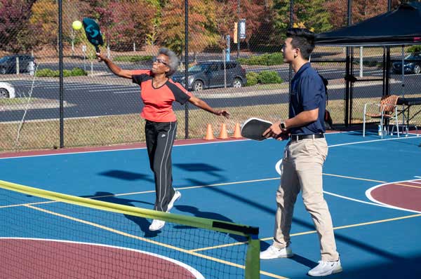 A woman and a man playing pickleball together.