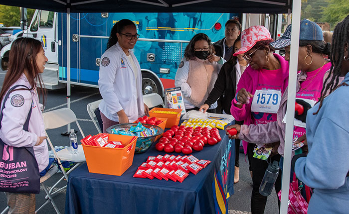 PCOM Georgia pharmacy students provide health information and screenings to patrons under a tent