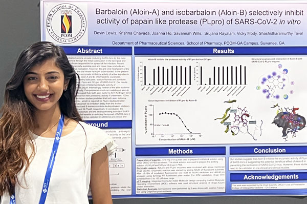 PCOM Georgia student Krishna Chavada smiling in front of a COVID research poster