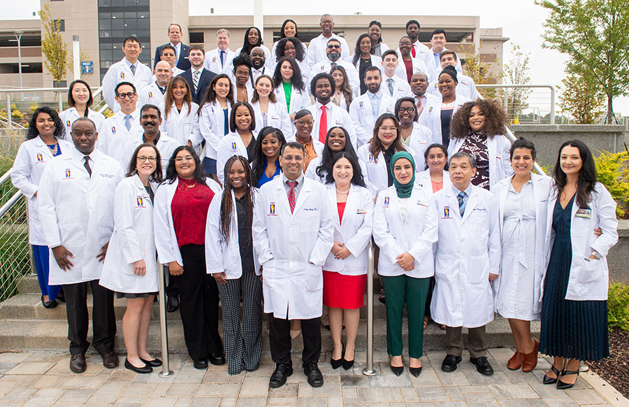 PCOM Georgia PharmD students and faculty smile in a large group shot after the white coat ceremony