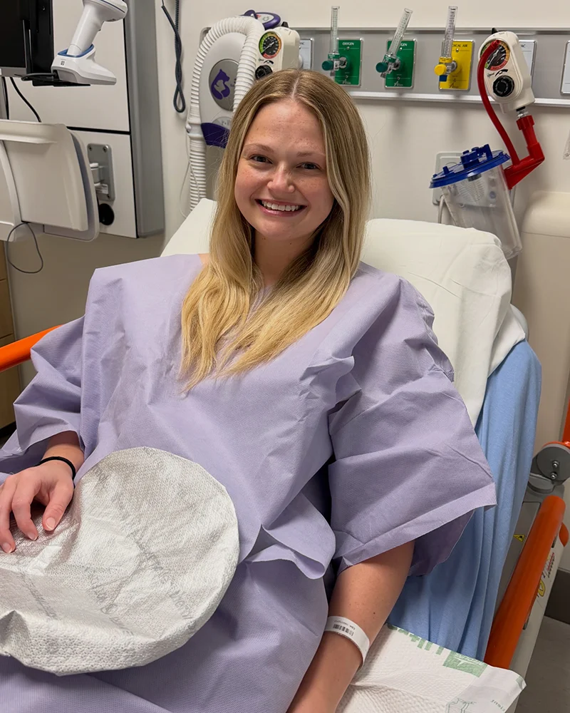 DO student Kiera Curry smiling in a hospital bed prior to starting bone marrow procurement surgery