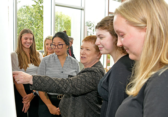 Dr. Ruth Maher points to a poster board and talks to GGC excercise science students