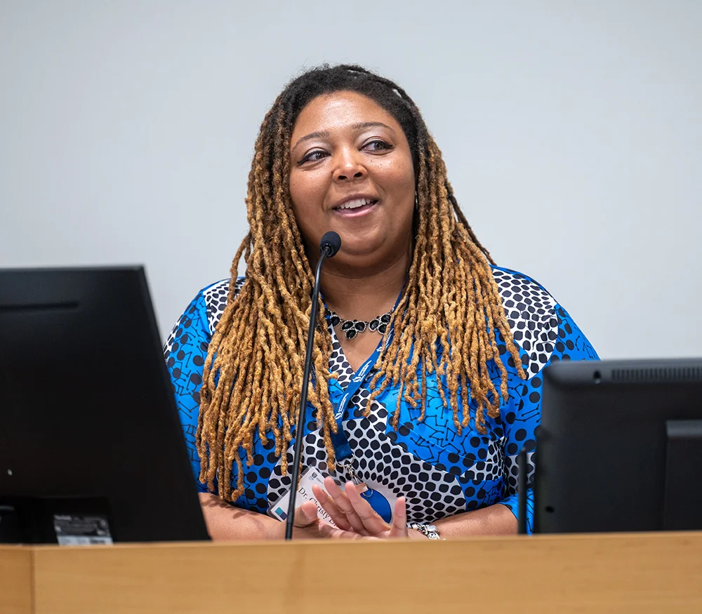 PCOM Georgia's Campus and Community Partnerships Director Dr. Christy Dinkins speaks at a podium during the Opportunities Academy summer STEM program