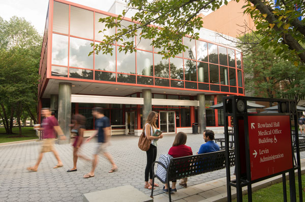 Photo of psychology students walking by the front of PCOM's main classroom building - Evans Hall