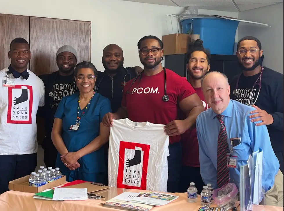 PCOM DO students as part of the Brothers in Medicine student group smile with community physicians during a public health event in Germantown, PA