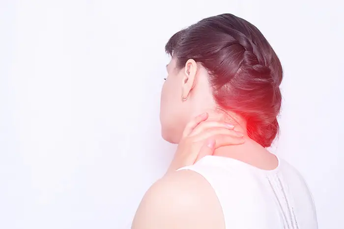 Photo of a woman rubbing a fibromyalgia pain point on the back of her shoulder