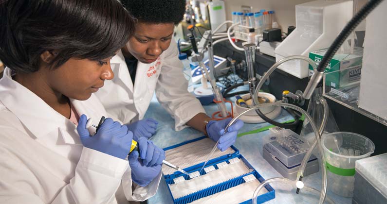 Photograph of Dr. Hatcher and a student working in a laboratory.