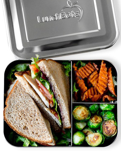Stainless steel LunchBots bento style box with a sandwich, fruit and veggies.