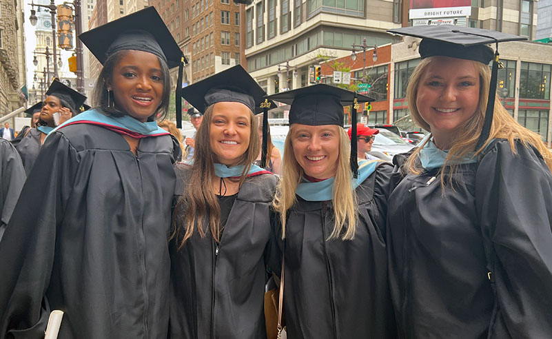 PCOM grad students smile outside the Academy of Music after graduation