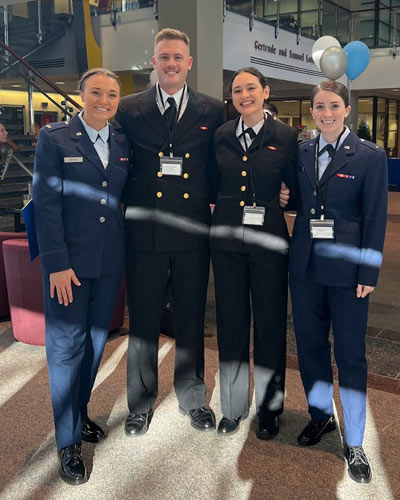 Four PCOM medical students stand side-by-side dressed in their military uniforms