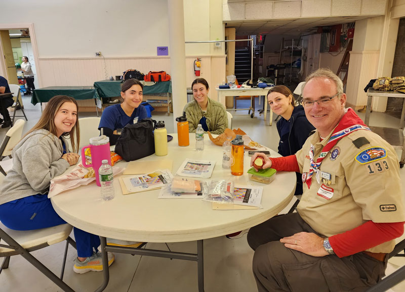 Dr. Erik Langenau eats lunch at a table with medical students