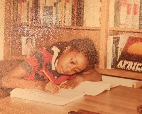 Dr. Hatcher as a child studying and writing in notebook