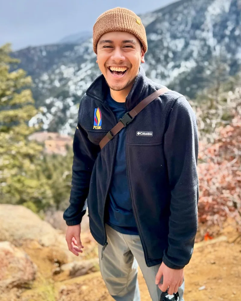 PCOM medical student Antonio Almeda-Lopez (DO '26) smiles while hiking in the mountains