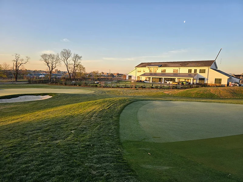 View of white lodge on golf course at sunrise
