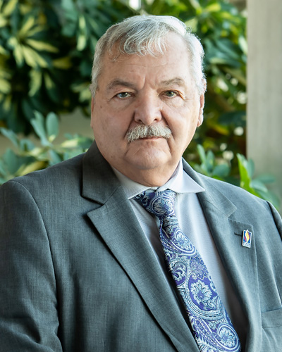 Headshot photograph of William B. Swallow, DO '79, smiling and wearing a suit.