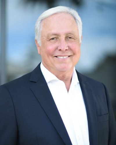 Headshot photograph of Norman Edward Vinn, DO, smiling and wearing a suit.