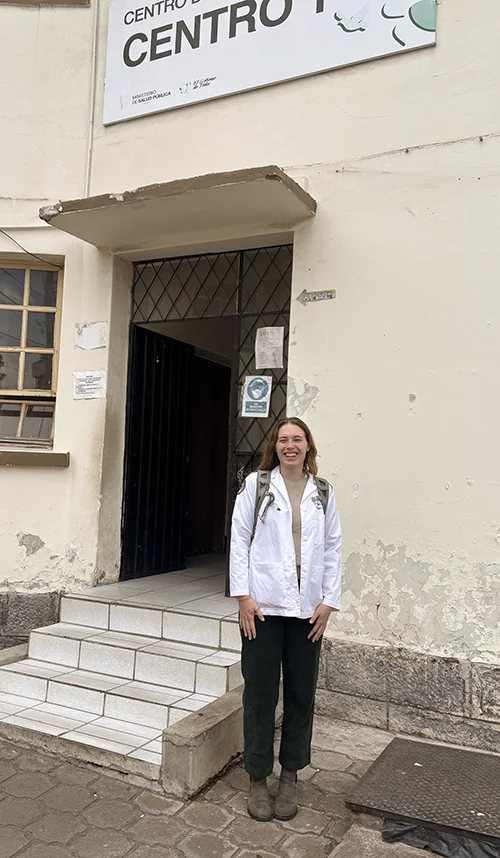 DO student Addison Brearton smiles in front of a clinic during her time in Ecuador learning OBGYN during a Medical Spanish elective