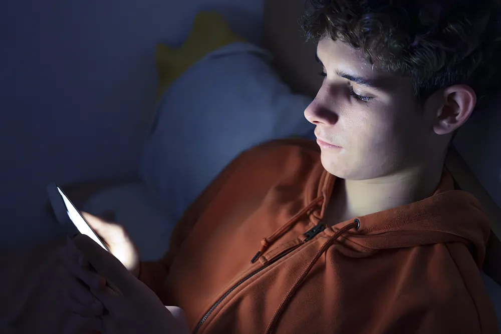 A teenager using an AI chatbot for therapy related questions on their phone screen