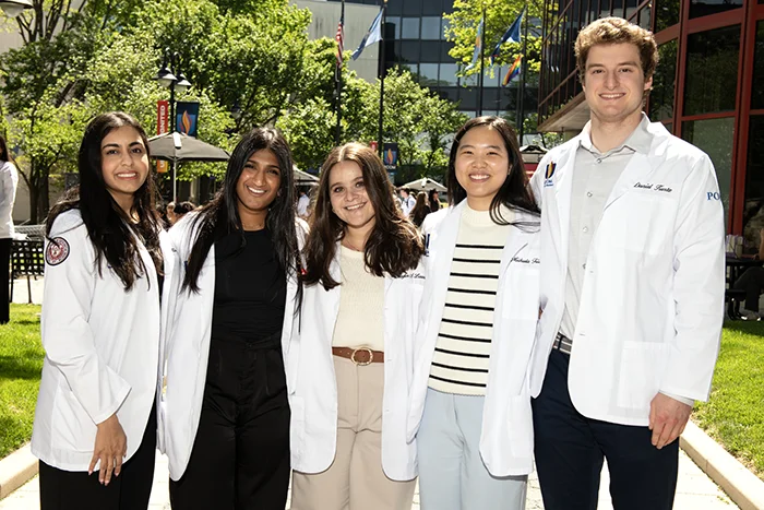 Members of PCOM's Dermatology Club stand shoulder to shoulder in the Philadelphia campus courtyard