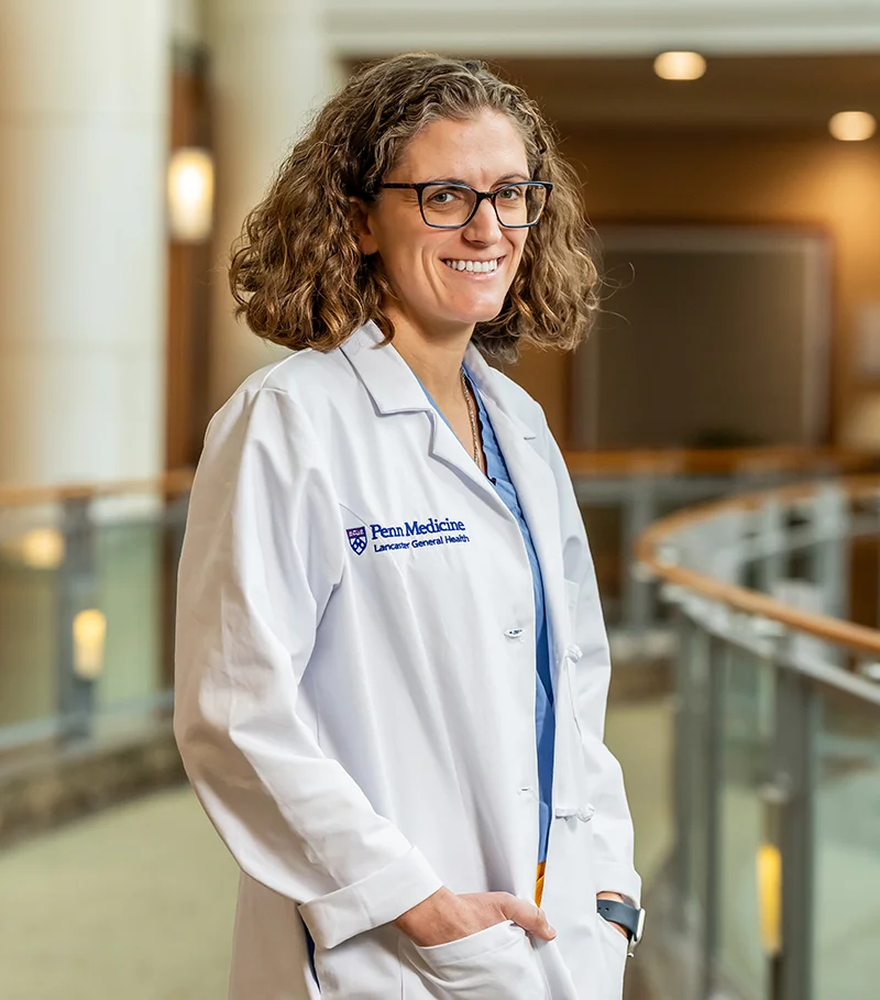 PCOM faculty and general surgery residency program director, Lindsey Perea, DO, FACS, smiles in a hospital lobby area