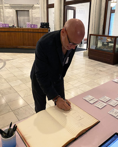 Dr. Greg McDonald signs the Book of Fellows during the induction ceremony.