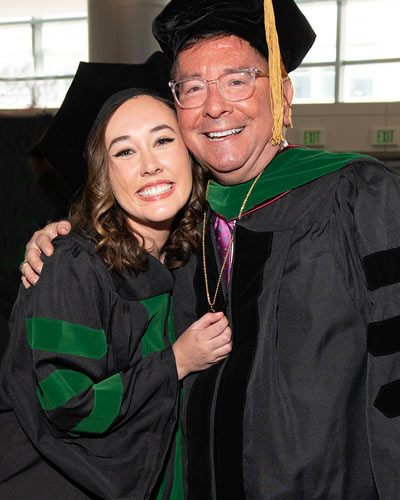 Claire and Michael Becker wearing graduation regalia