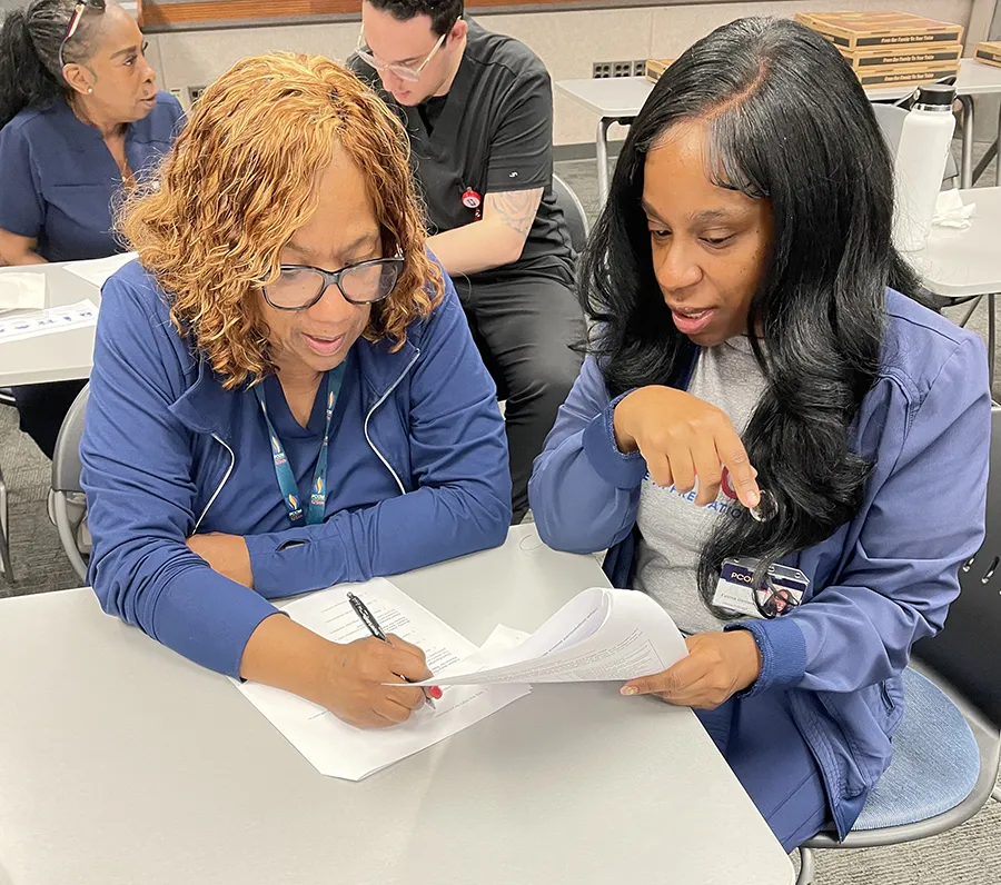 Healthcare staff trainees conduct a team exercise during PCOM's Effective Patient Communication Training program