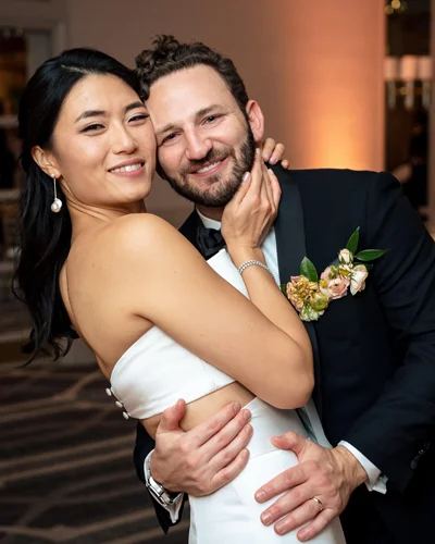 Hanna Kim wears white dress while embracing her husband