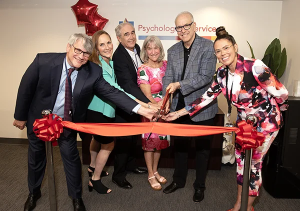PCOM faculty and staff pose for ribbon cutting photo
