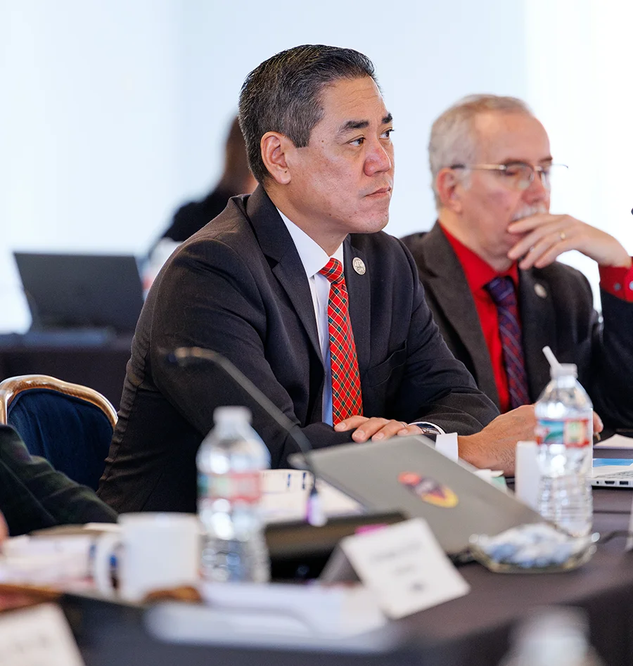 Dr. Kuo listening at a conference room table during an NBOME board meeting
