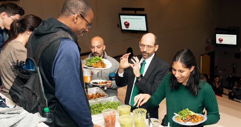 Dr. Michael Greger speaks with students as they add food to their plates