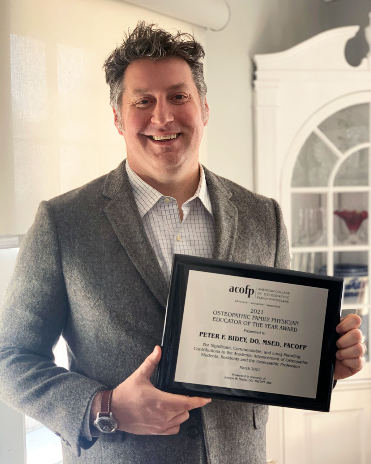 PCOM professor Peter Bidey is shown with his ACOFP Educator of the Year award.