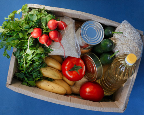 Box full of produce, rice, and canned food