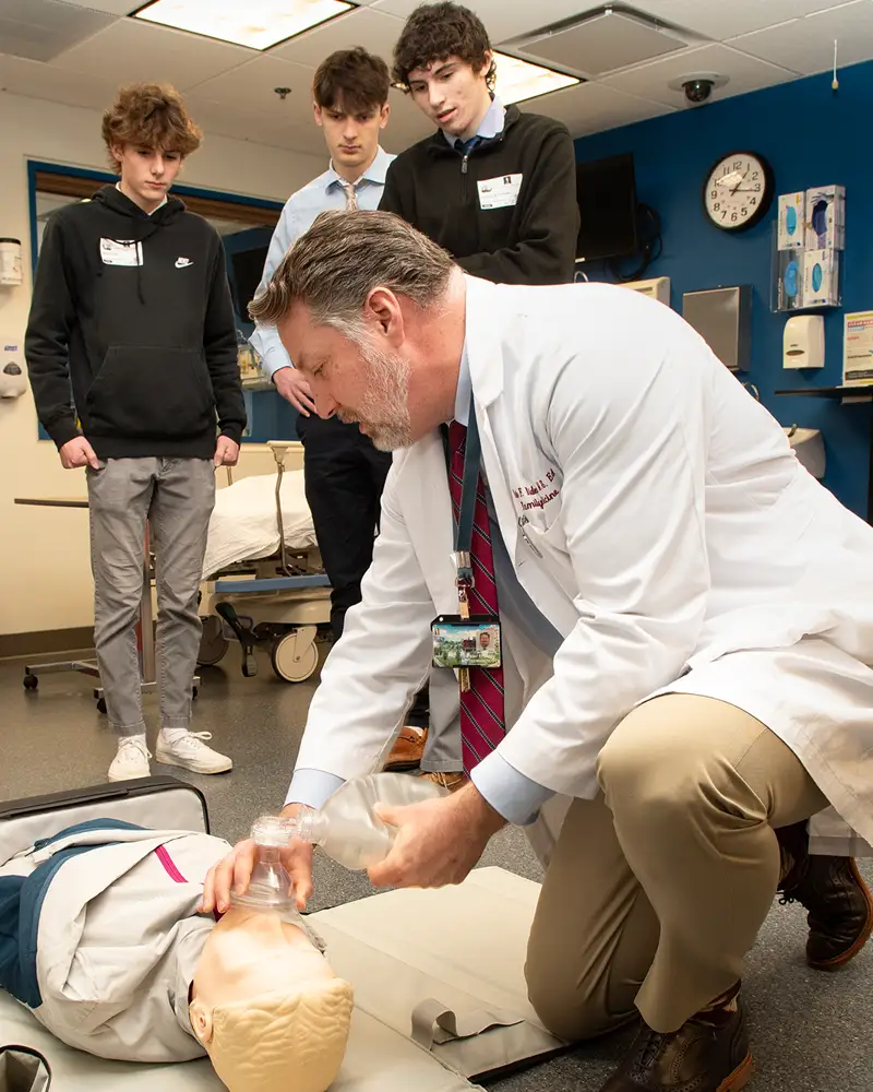 Dr. Bidey demonstrates on CPR manikin
