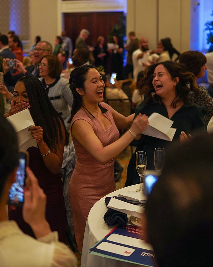 PCOM DO students shout and smile with excitement as they open their residency match letters during the Match Day celebration event