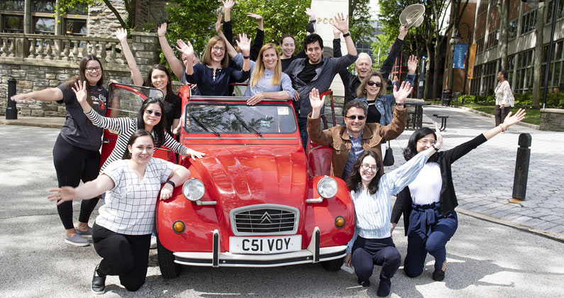 PCOM faculty, staff and students pose with the KDA's Citroen 2CV