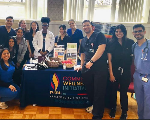 Members of PCOM Hearts pose by an event table