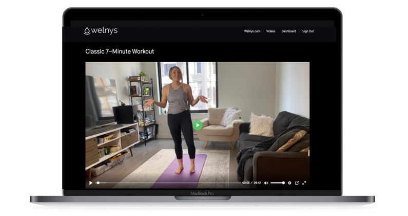 Photo of a laptop streaming a Welnys yoga course video.