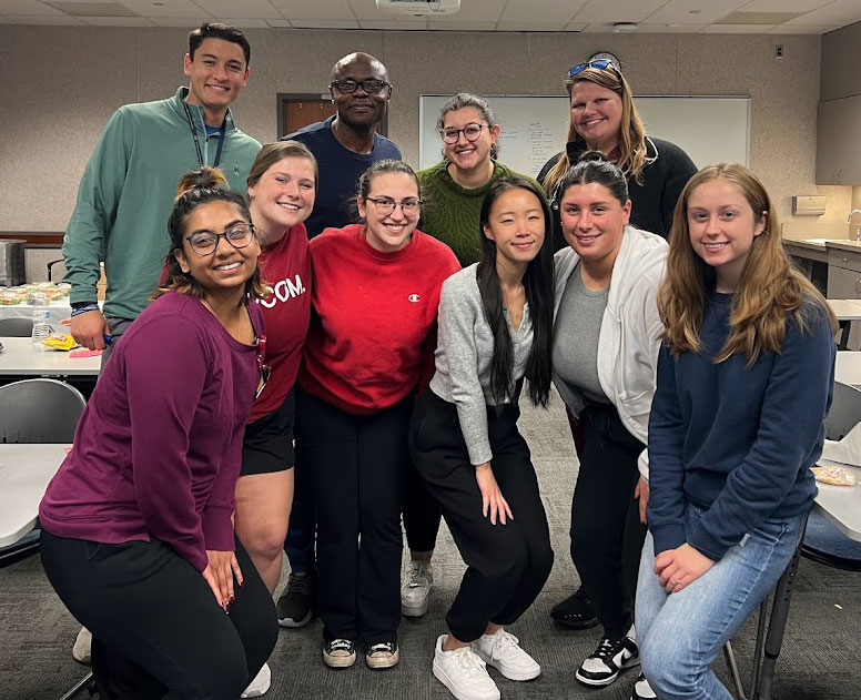 PCOM's first-gen students smile and mingle in a classroom on the Philadelphia campus