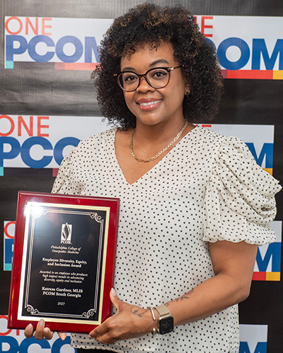 PCOM South Georgia librarian Katresa Gardner smiles as she holds her DEI award