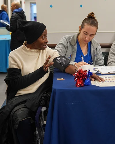 PCOM medical student takes blood pressure reading for community member