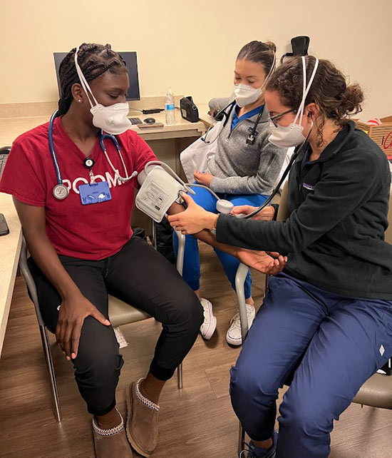 PCOM students assist with taking blood pressure screenings at the CWI event.